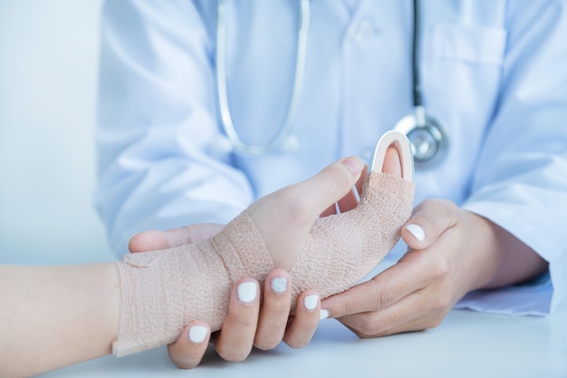les mains du médecin tenant le patient dans l'accident du bras pour encourager et expliquer les résultats de l'examen de santé