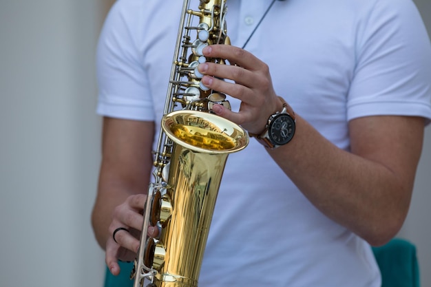 les mains du musicien jouent du saxophone