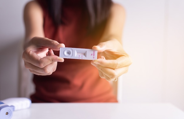 Photo mains du patient montrant le résultat d'un autotest rapide d'antigène covid-19 à la maison