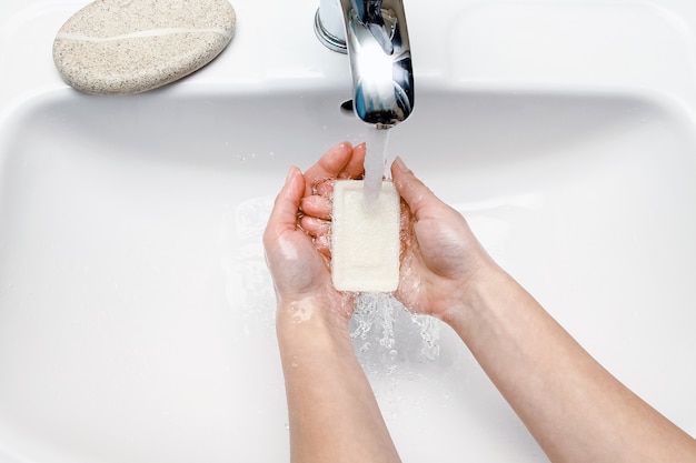 A Les mains avec du savon sont lavées sous le robinet avec de l'eau. Nettoyer de l'infection, de la saleté et des virus. À la maison ou au bureau des ablutions de l'hôpital.