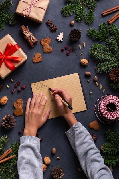 Mains d'enfant de concept de Noël écrivant la lettre au père noël