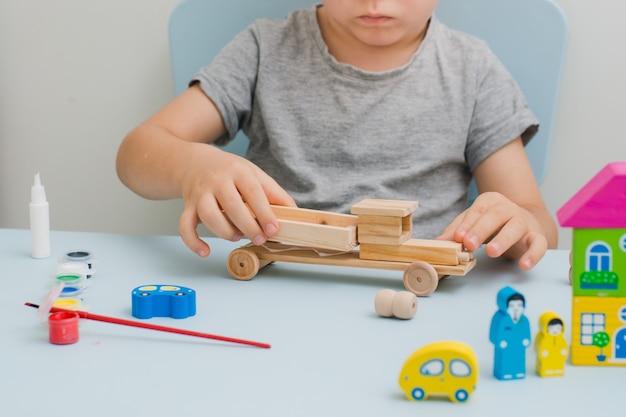 Les mains d&#39;un enfant peignent une machine en bois