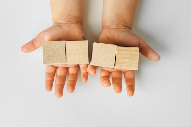 Mains d'un enfant avec quatre blocs de bois, vue du dessus