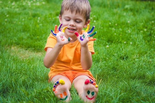 Les mains des enfants aux couleurs de l'été un sourire sur la paume du garçon