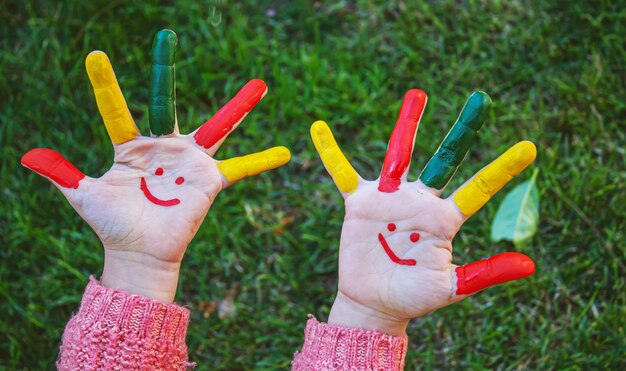 Les mains des enfants en couleurs. Photo d'été. Mise au point sélective.