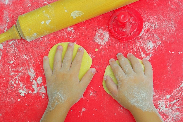 Les mains des enfants dans la farine et la pâte