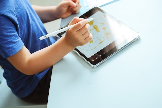 Mains D'enfants Dessinant Avec Un Stylo Numérique Sur L'image De La Tablette Avec Espace De Copie Photo De Haute Qualité