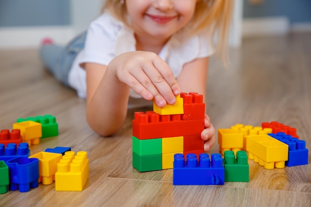 Mains d'enfants un enfant jouant un constructeur à la maison sur le sol