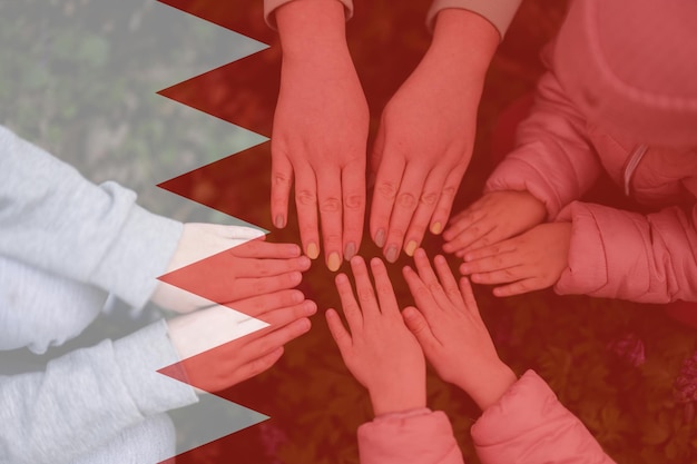 Mains d'enfants sur fond de drapeau de Bahreïn Concept de patriotisme et d'unité de Bahreïn