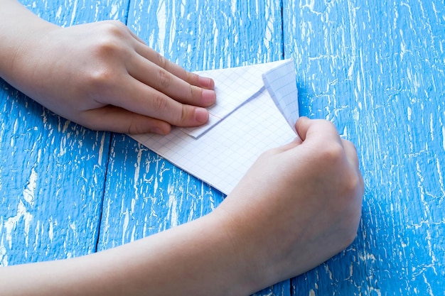 Les mains des enfants ont fait un bateau en origami en papier