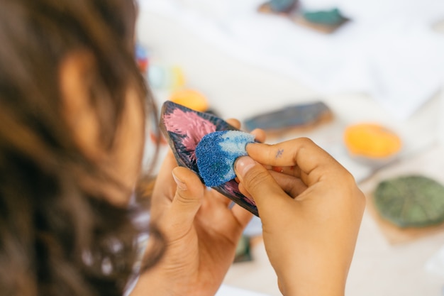 Mains d'enfants peignant des timbres en bois.