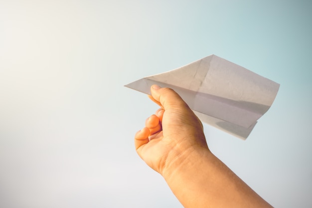 Les mains des enfants ramassent des avions en papier.