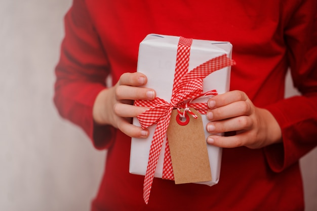 Mains d'enfants tenant une boîte de cadeau de Noël.