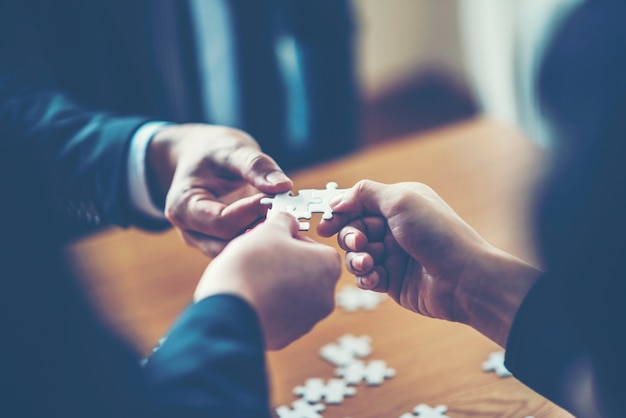 mains essayant de relier la pièce de puzzle de couple avec le fond, une partie de l&#39;ensemble