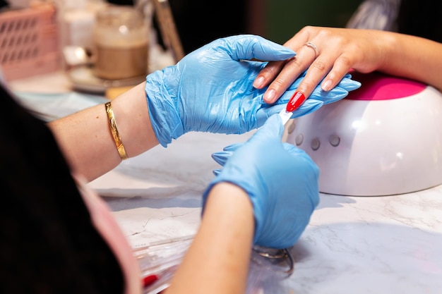 Mains d'esthéticiennes testant les couleurs de vernis à ongles