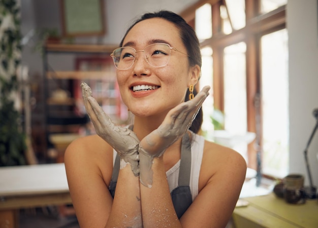 Mains face et sales avec une femme asiatique professionnelle de la poterie assise dans son studio ou atelier Art design et créatif avec une femme designer ou potière travaillant dans sa startup d'argile ou de céramique