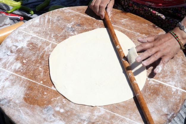 Mains faisant cuire la pâte avec un rouleau à pâtisserie