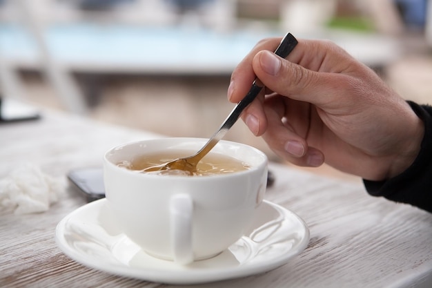 Mains faisant une tasse de thé