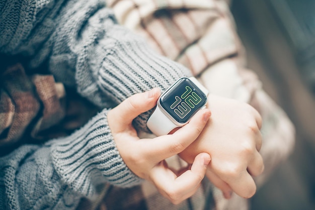 Mains féminines à l'aide d'une montre intelligente à écran tactile Vue de dessus