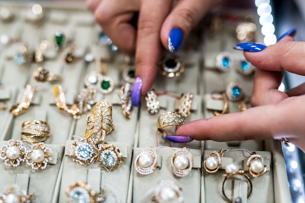 Mains féminines avec des bijoux en or en gros plan