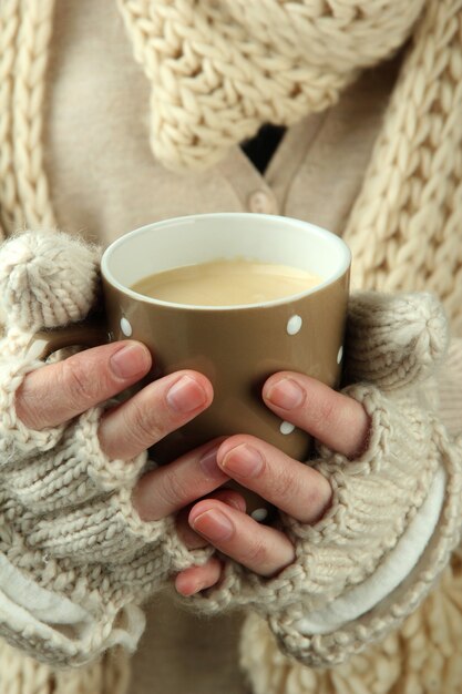 Mains féminines avec boisson chaude, gros plan