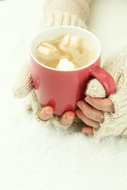 Mains féminines avec boisson frappée, sur fond clair