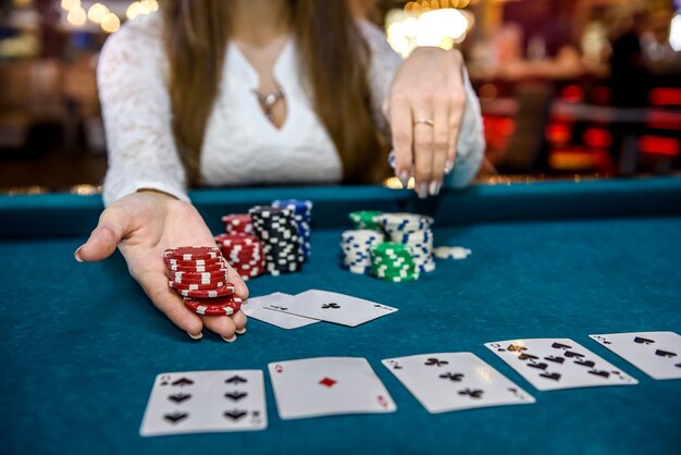 Mains féminines avec des cartes à jouer et des jetons de poker