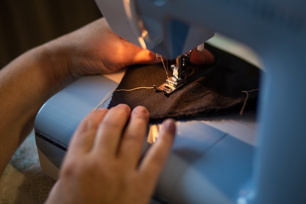 mains féminines coud sur une machine à coudre