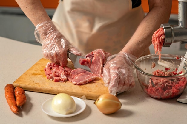 mains féminines coupant la viande pour la viande hachée mise au point sélective