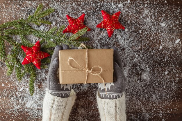 Mains féminines dans des gants d'hiver avec boîte-cadeau de Noël