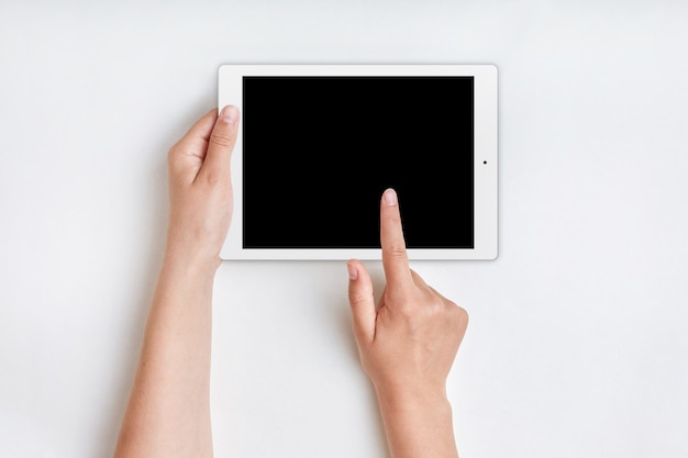 Photo mains féminines détient ordinateur tablette avec écran blanc sur blanc