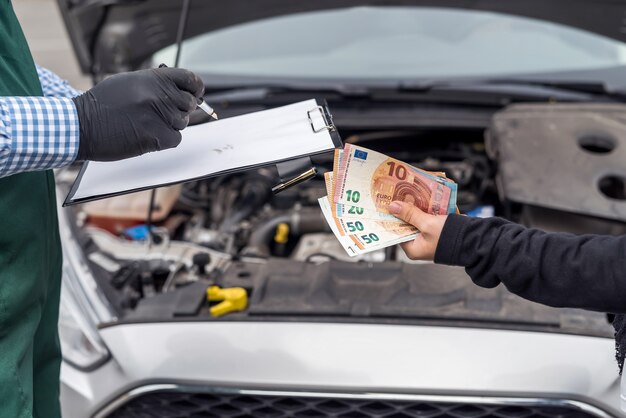 Mains féminines donnant des billets en euros pour le service de voiture