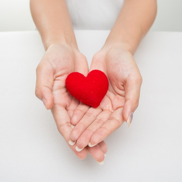 Mains féminines donnant le coeur rouge