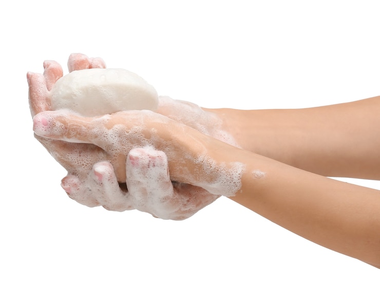 Photo mains féminines avec du savon sur blanc