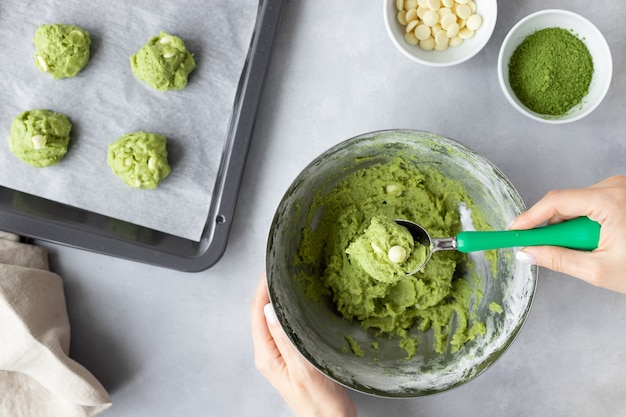 mains féminines faisant biscuit au thé vert matcha