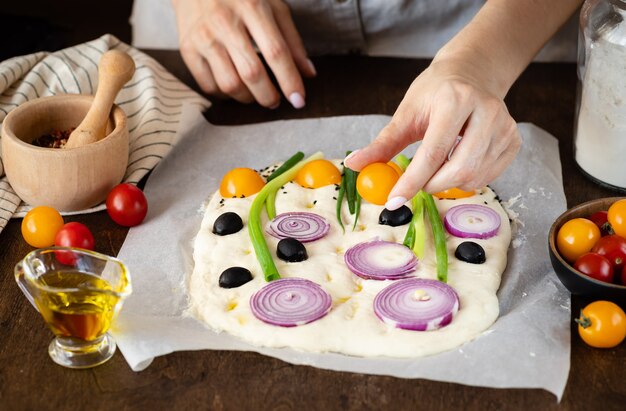 Mains féminines faisant du pain d'art focaccia italien Alimentation saine