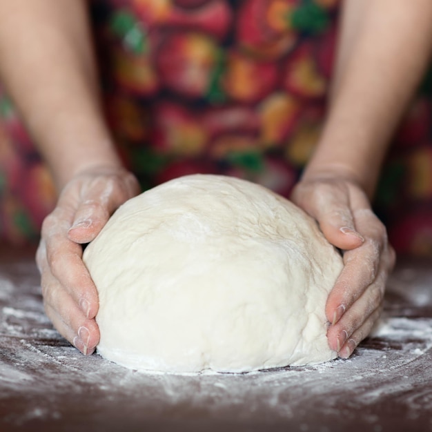 Mains féminines faisant de la pâte. Processus de pétrissage de la pâte. Pâte à base de levain naturel. Pâte de blé.