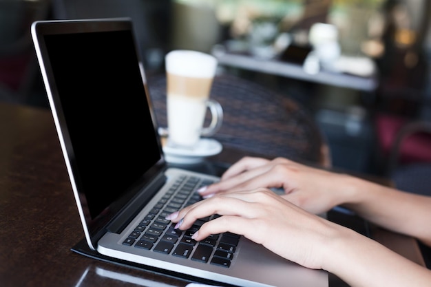 Mains féminines avec gros plan d'ordinateur portable. Femme travaillant à l'extérieur sur ordinateur avec écran vide pour l'espace de copie. Technologie, communication et concept de travail à distance.