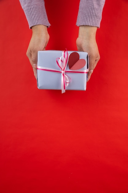 Mains féminines offrant un cadeau de la Saint-Valentin