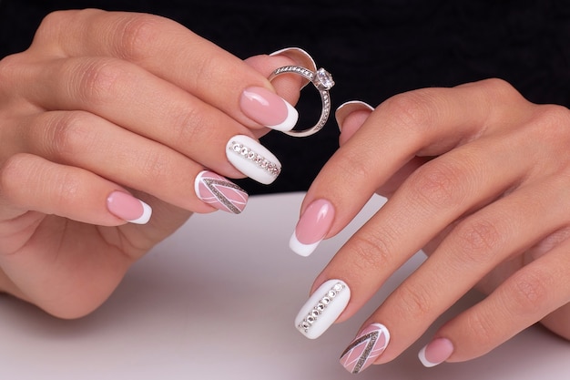 Mains féminines avec des ongles de manucure de mariage