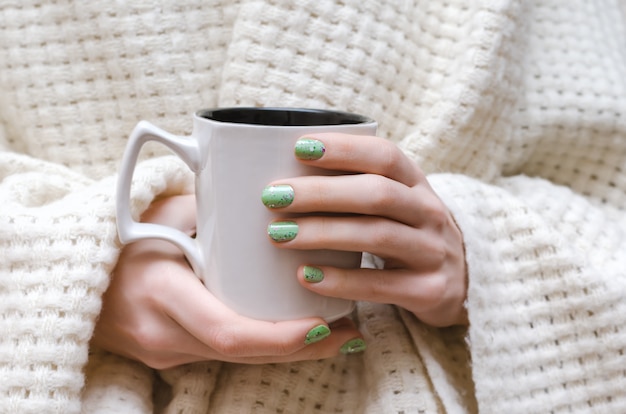 Mains féminines avec des ongles verts scintillants