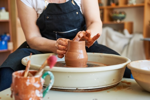 Mains féminines d'un potier travaillant sur un cercle. Artisanat folklorique traditionnel.