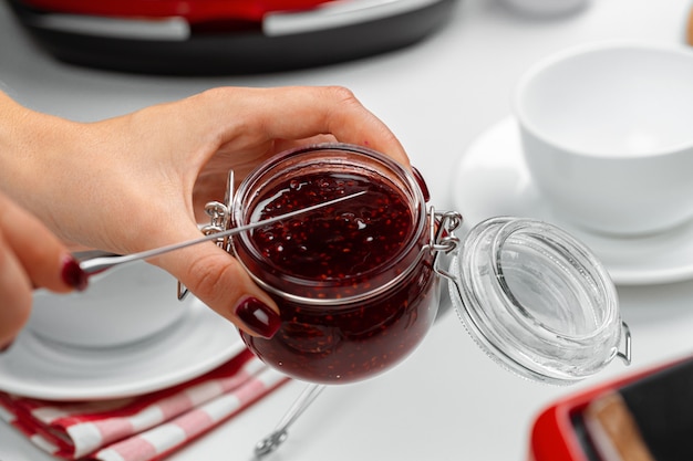 Mains féminines préparer des toasts avec de la confiture de fruits