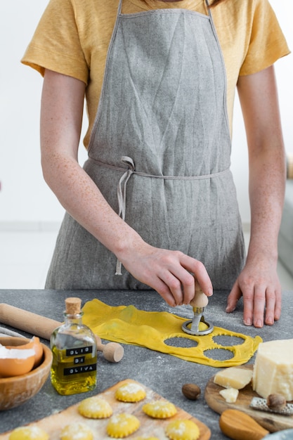 Mains féminines, processus de préparation des pâtes italiennes faites maison, raviolis