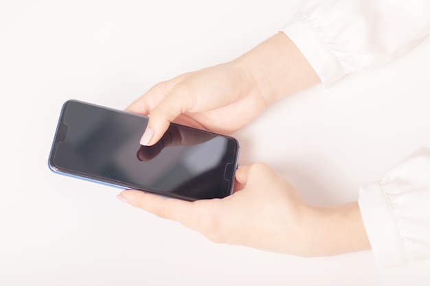 Mains féminines avec un smartphone à une table