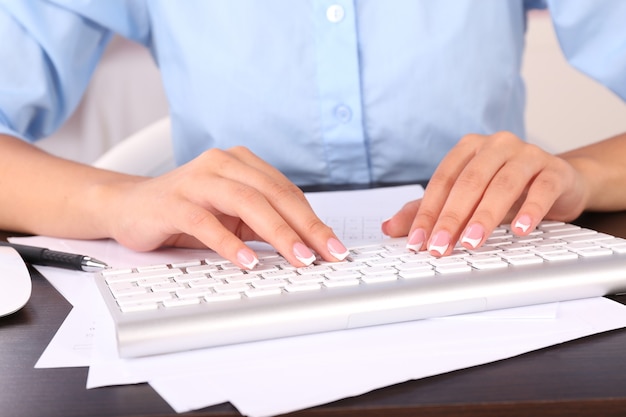 Mains féminines tapant sur le clavier, gros plan