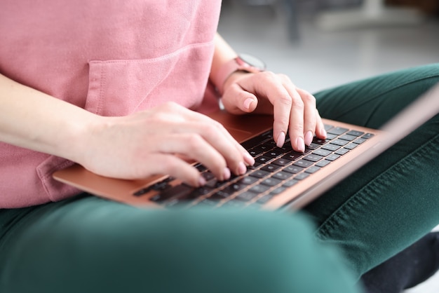 Mains féminines tapant sur le clavier d'ordinateur portable gros plan