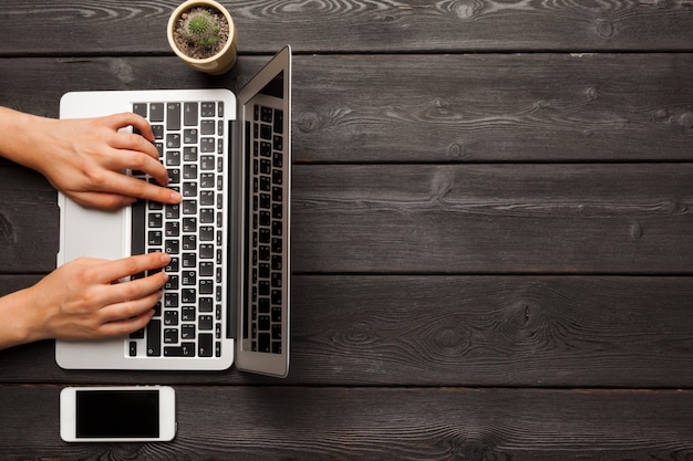 Mains féminines tapant sur une vue de dessus de clavier d'ordinateur portable