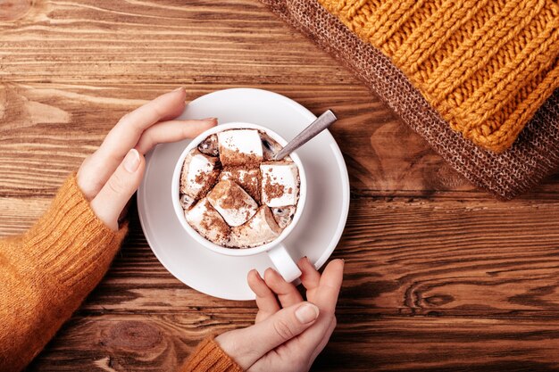 Photo mains féminines avec tasse de cacao à plat