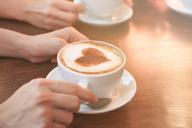 Mains féminines avec une tasse de café savoureux chaud au café vue rapprochée